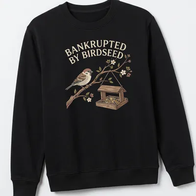 Illustrative t-shirt featuring a sparrow and the phrase 'Bankrupted By Birdseed' in earthy tones. — printed on a unisex sweatshirt