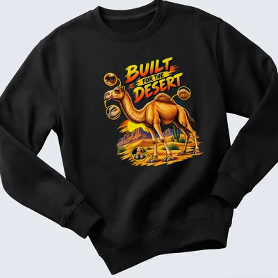 Vibrant cartoon of a camel with bold text 'BUILT FOR THE DESERT' in colorful desert scenery. — printed on a unisex sweatshirt