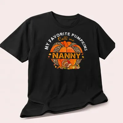 Watercolor design with a pumpkin and turkey above the text 'Call me Nanny' — printed on a unisex t-shirt (angled view)