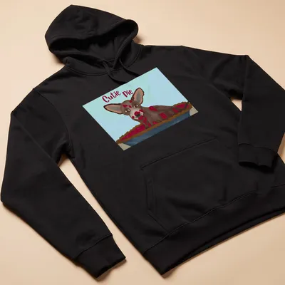 Whimsical illustration of a Chihuahua with the text 'Cutie Pie' in brown and cream colors — printed on a unisex hoodie