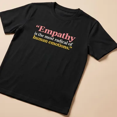Bold typography with the phrase Empathy is the most radical of human emotions in colorful design. — printed on a unisex t-shirt