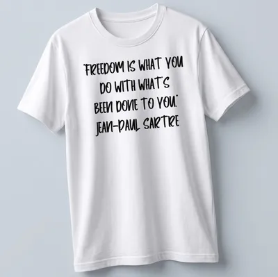 Bold handwritten text of Sartre's quote on freedom in black and white — printed on a unisex t-shirt