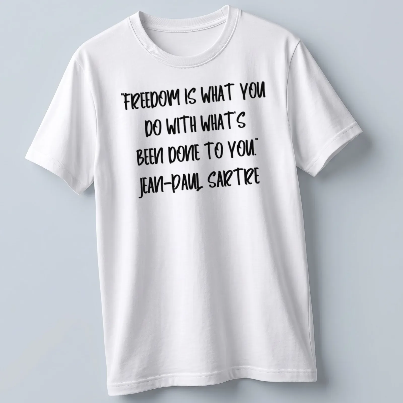 Bold handwritten text of Sartre's quote on freedom in black and white — printed on a unisex t-shirt
