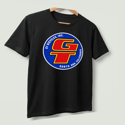 Vintage BMX T-shirt featuring GT Bicycles logo in blue, red, yellow, and white — printed on a unisex t-shirt (angled view)