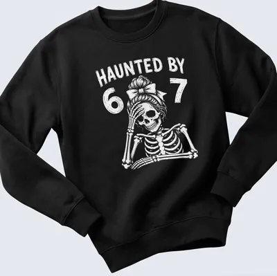 Cartoon skeleton teacher graphic with the text 'Haunted By 67' in black and white — printed on a unisex sweatshirt