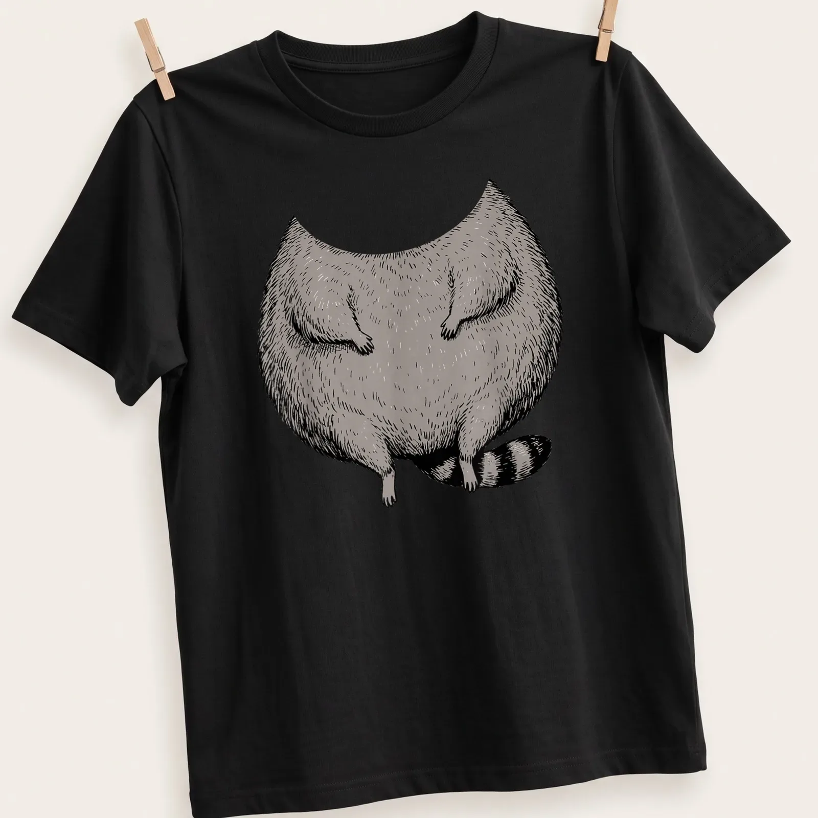 Cartoon illustration of a fat raccoon in a costume in gray, black, and white — printed on a unisex t-shirt