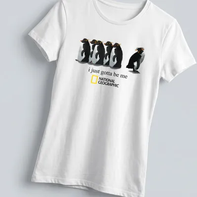 Illustrative penguin design with the text 'i just gotta be me' in black and orange. — printed on a women's shirt