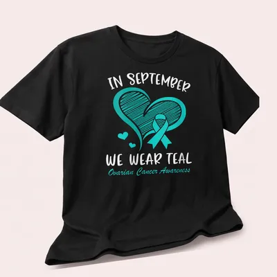 Teal Ovarian Cancer Awareness shirt with teal ribbon and heart design — printed on a unisex t-shirt (angled view)