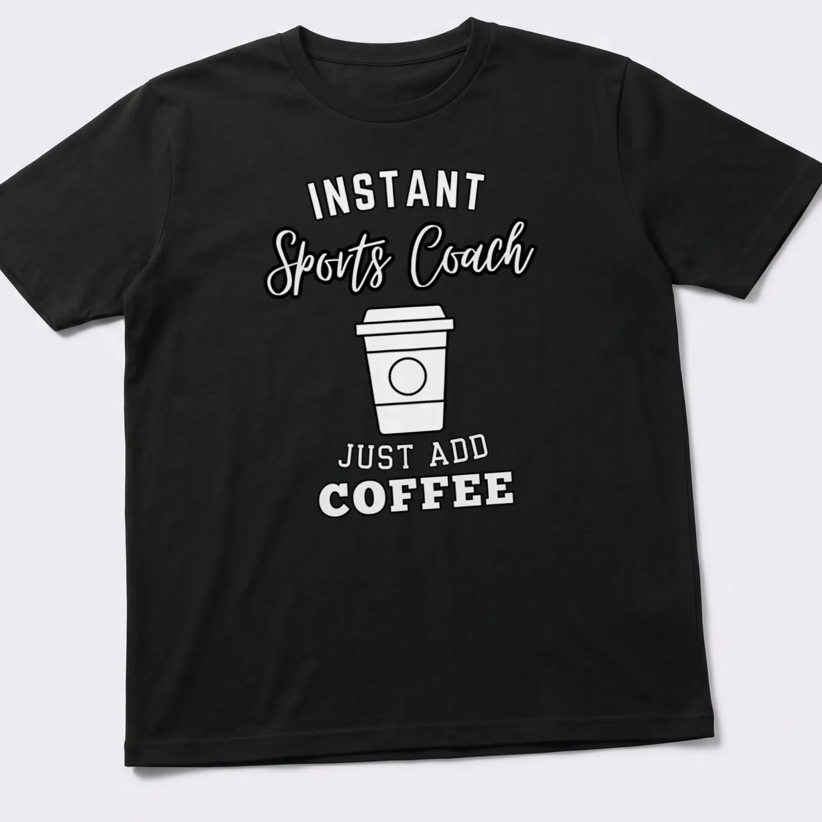 Bold typography shirt with 'Instant Sports Coach Just Add Coffee' text above a coffee cup graphic. — printed on a unisex t-shirt