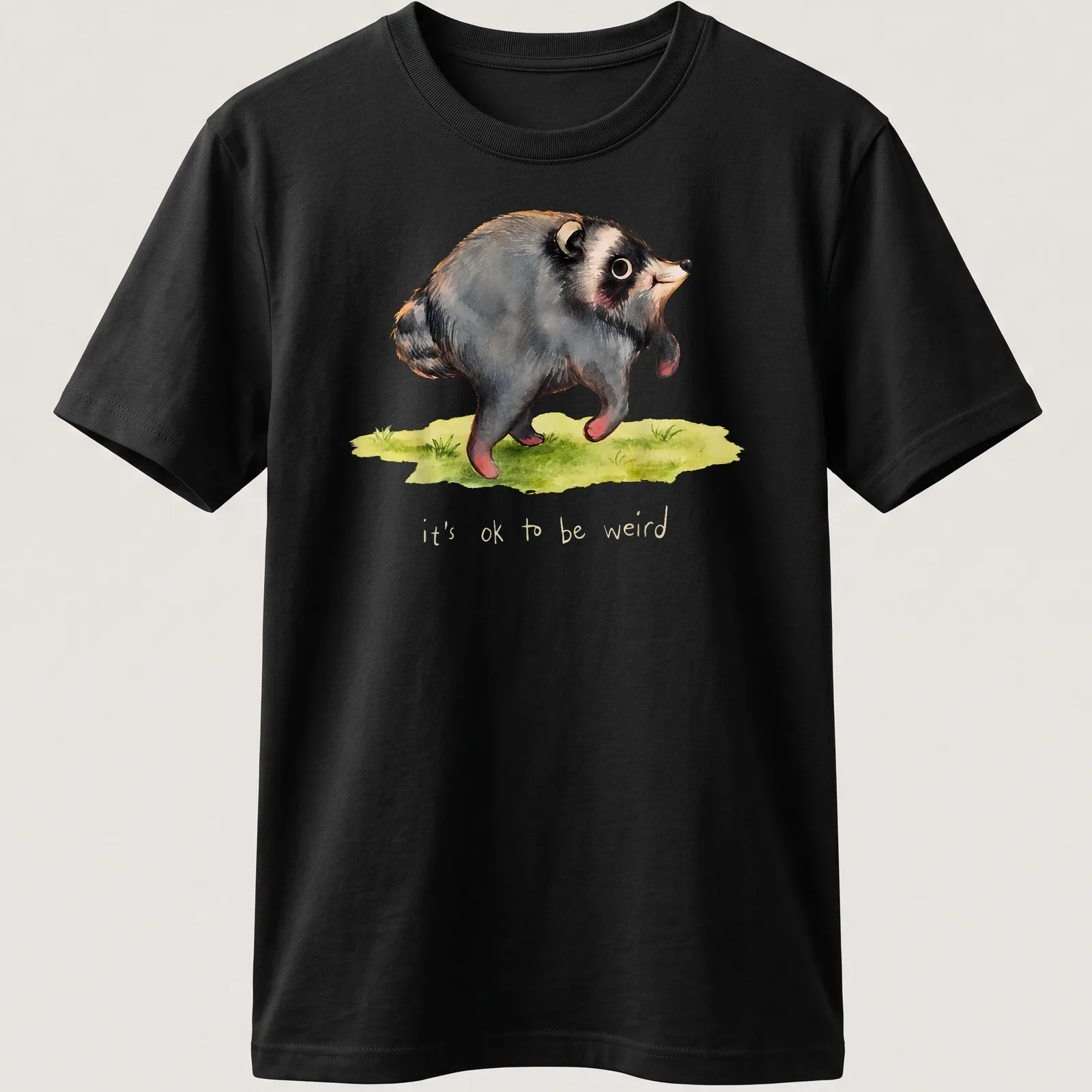 Watercolor print of a raccoon with the text it's ok to be weird in soft colors. — printed on a unisex t-shirt