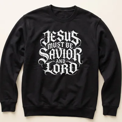 Ornate lettering of 'Jesus Must Be Savior And Lord' in black and white — printed on a unisex sweatshirt
