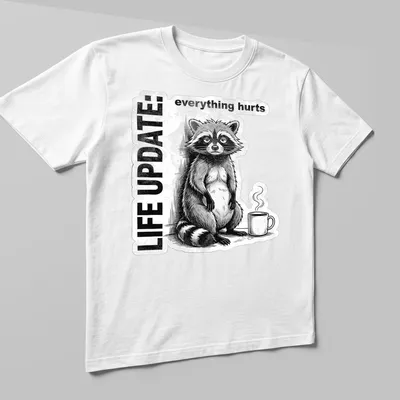 Vintage illustration of a raccoon with text reading Life Update: everything hurts in black, white, and gray — printed on a unisex t-shirt (angled view)