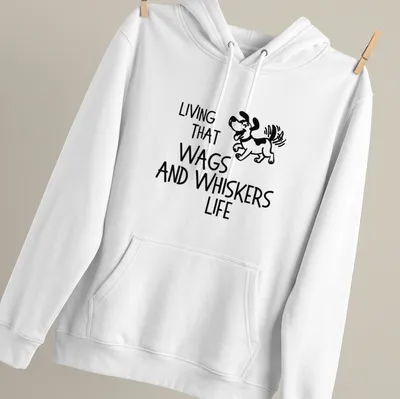 Playful line-art of a cartoon dog with the phrase 'Living That Wags And Whiskers Life' below — printed on a unisex hoodie