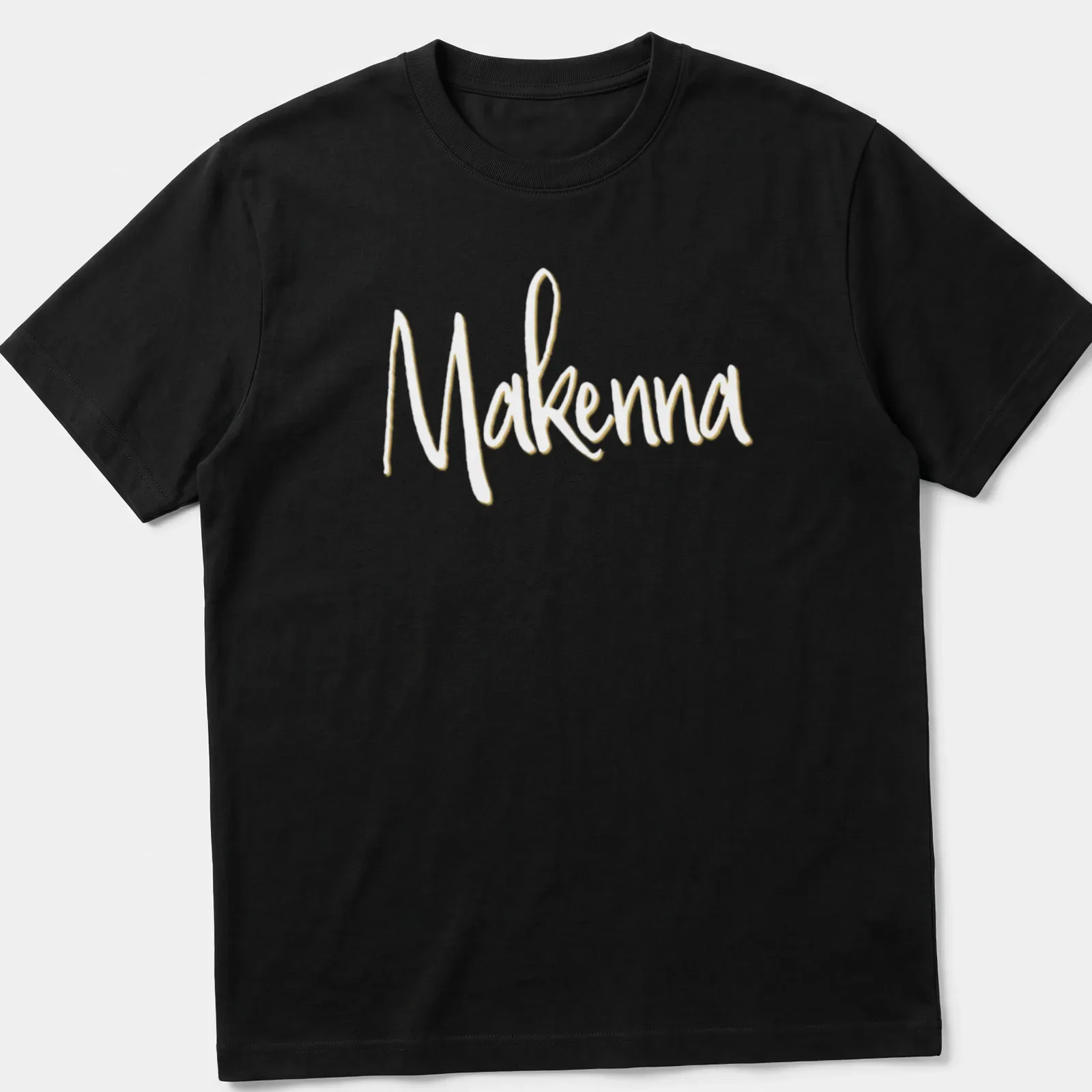 Personalized T-shirt with the name Makenna in elegant gold script — printed on a unisex t-shirt