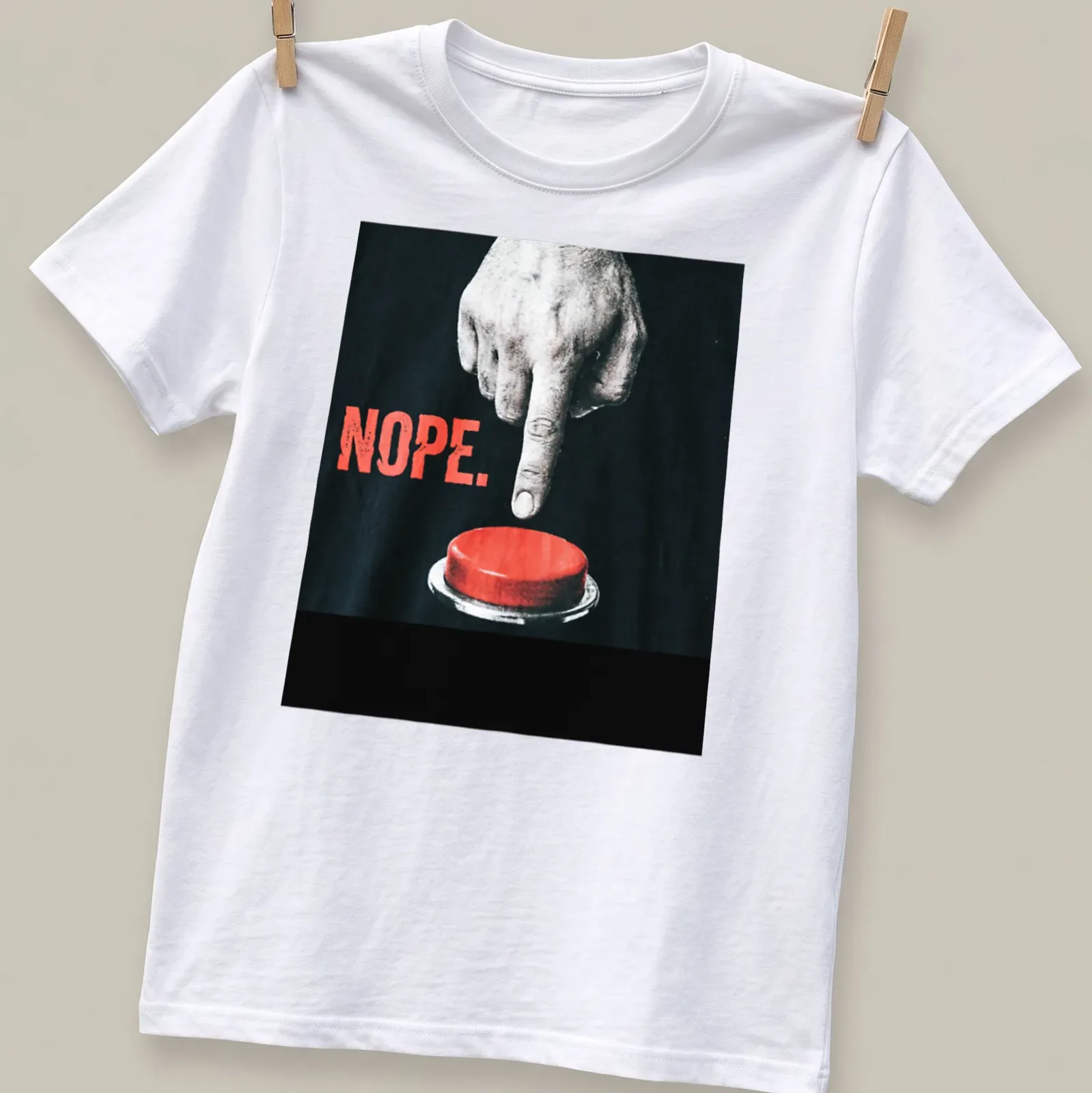 Minimalist graphic of a hand pressing a red button with the word 'NOPE.' — printed on a unisex t-shirt