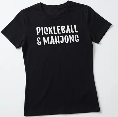 Bold typography design featuring pickleball and mahjong text in white — printed on a women's shirt