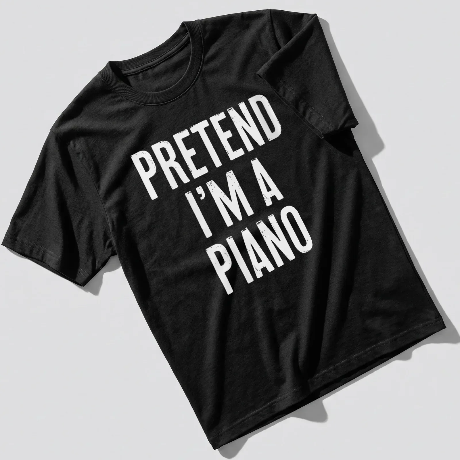 Simple white t-shirt with the text 'Pretend I'm A Piano' in bold lettering. — printed on a unisex t-shirt