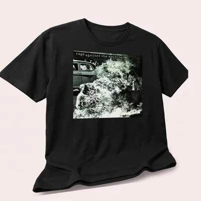 Vintage photo print of a protest with text 'rage against the machine' in black and white — printed on a unisex t-shirt (angled view)