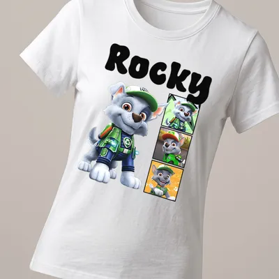 Cartoon design of Rocky from Paw Patrol in gray, green, blue, and orange — printed on a women's shirt