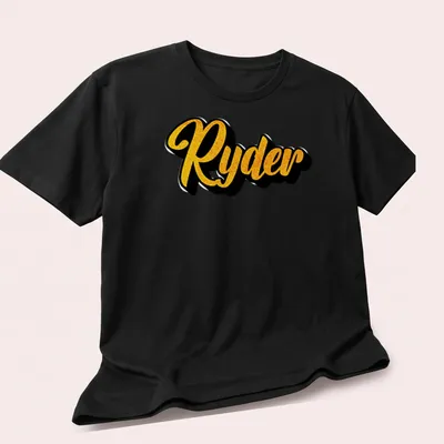 Personalized boys T-shirt with bold yellow script reading 'Ryder' on black — printed on a unisex t-shirt (angled view)