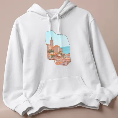 Watercolor coastal village scene with 'spain' text in soft colors — printed on a unisex hoodie
