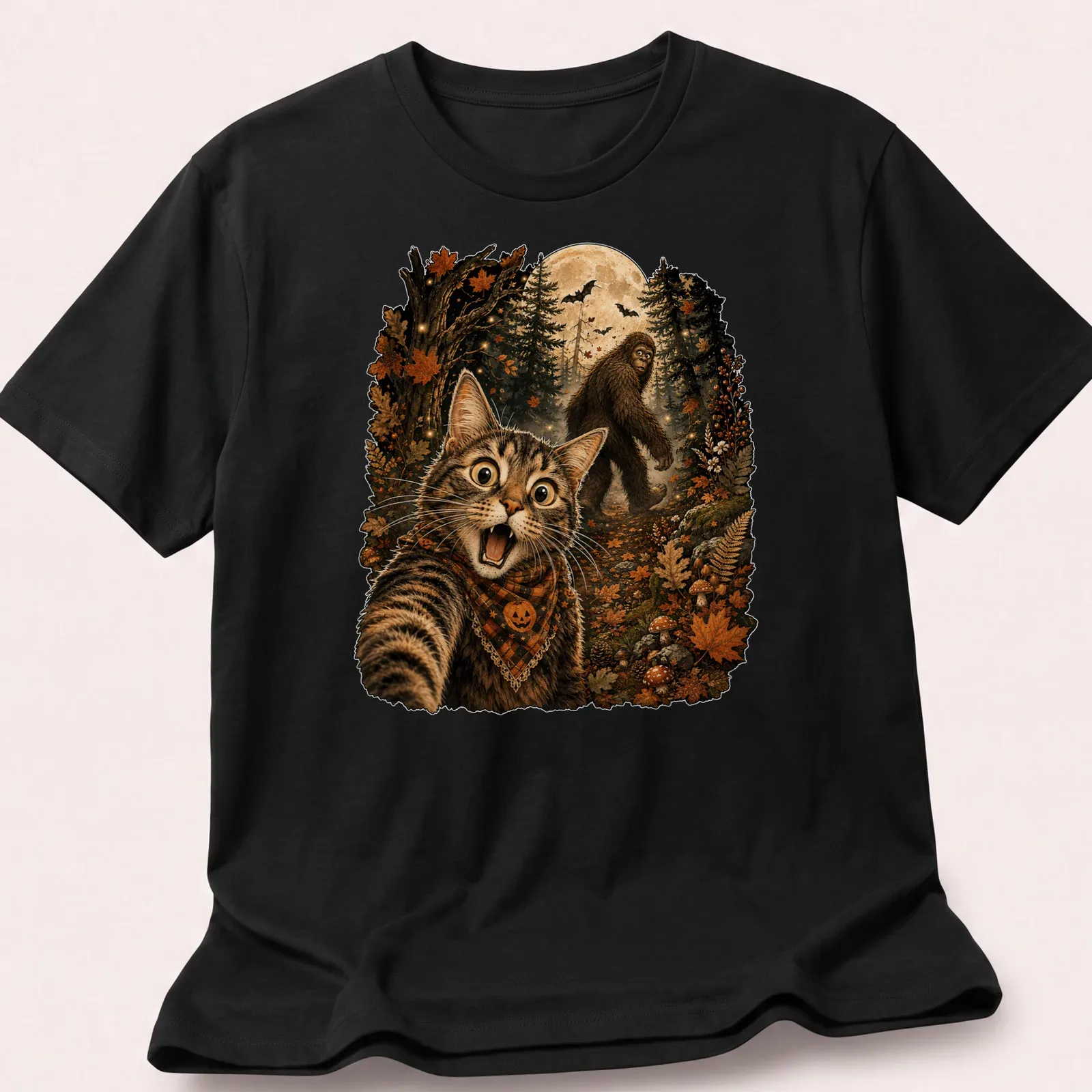 Detailed illustration of a cat taking a selfie with Sasquatch in Halloween colors — printed on a unisex t-shirt