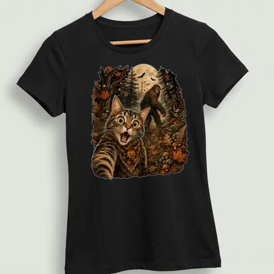 Detailed illustration of a cat taking a selfie with Sasquatch in Halloween colors — printed on a women's shirt