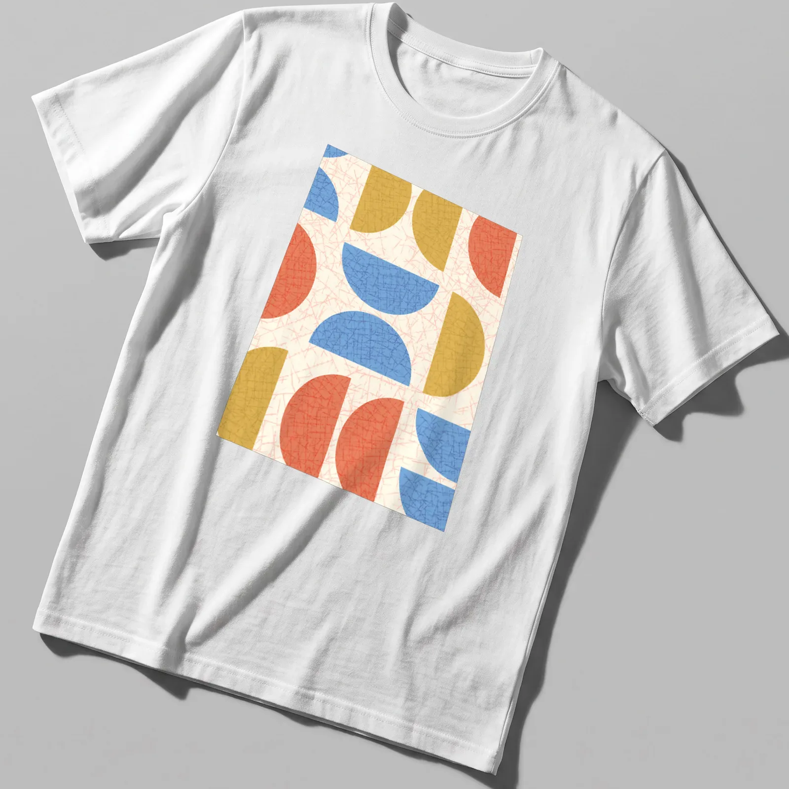 Modern geometric semicircles in cream, blue, red, and gold on — printed on a unisex t-shirt