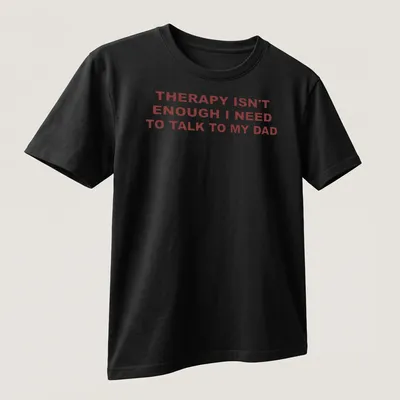 Bold typography shirt stating 'THERAPY ISN'T ENOUGH I NEED TO TALK TO MY DAD' in red on white. — printed on a unisex t-shirt (angled view)
