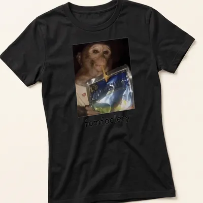 Realistic print of a monkey drinking juice from a pouch, featuring vibrant colors — printed on a women's shirt