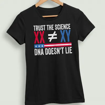 Bold graphic t-shirt displaying Trust The Science XX ≠ XY DNA Doesn't Lie in red, blue, and white — printed on a women's shirt