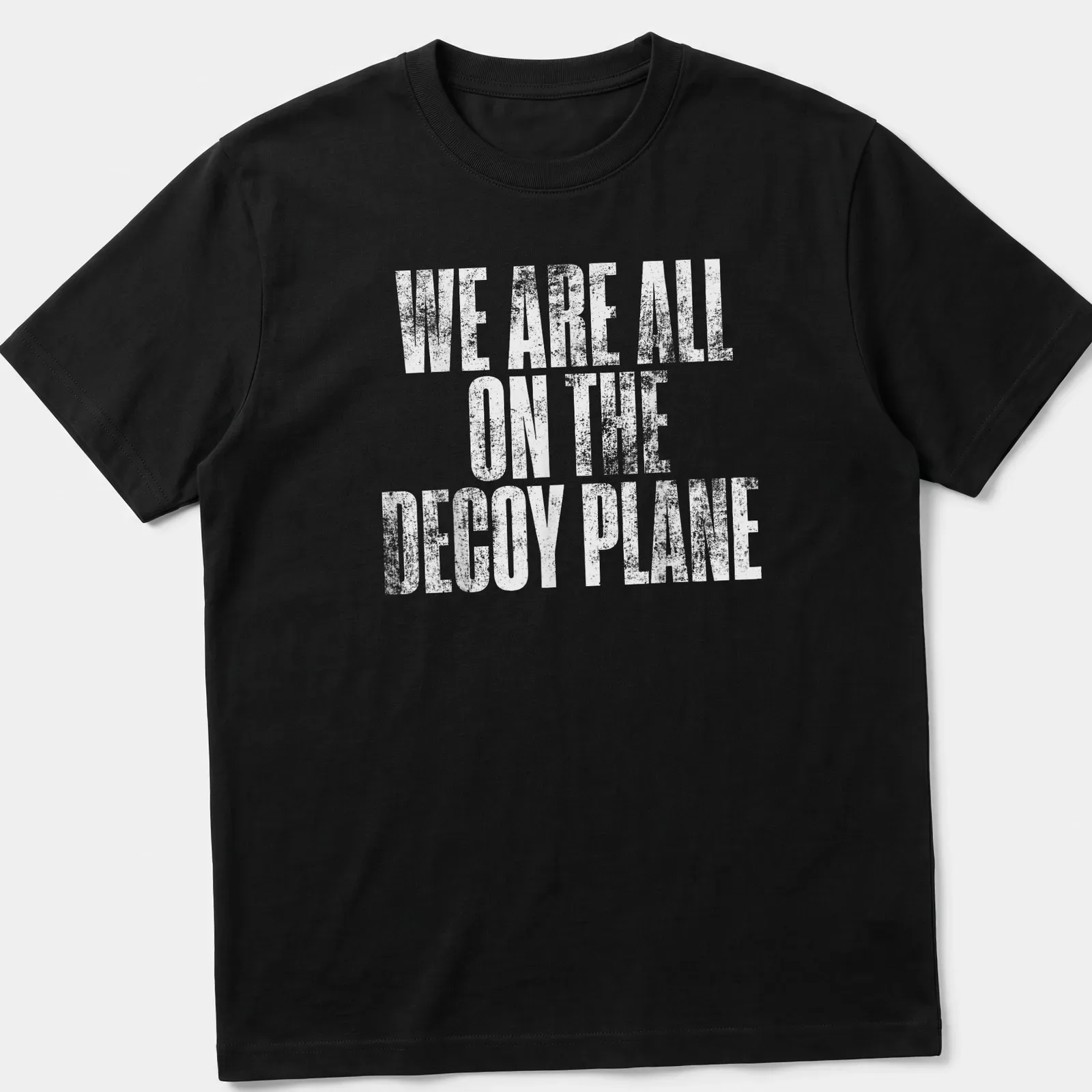 Distressed print of the phrase We Are All On The Decoy Plane in white — printed on a unisex t-shirt